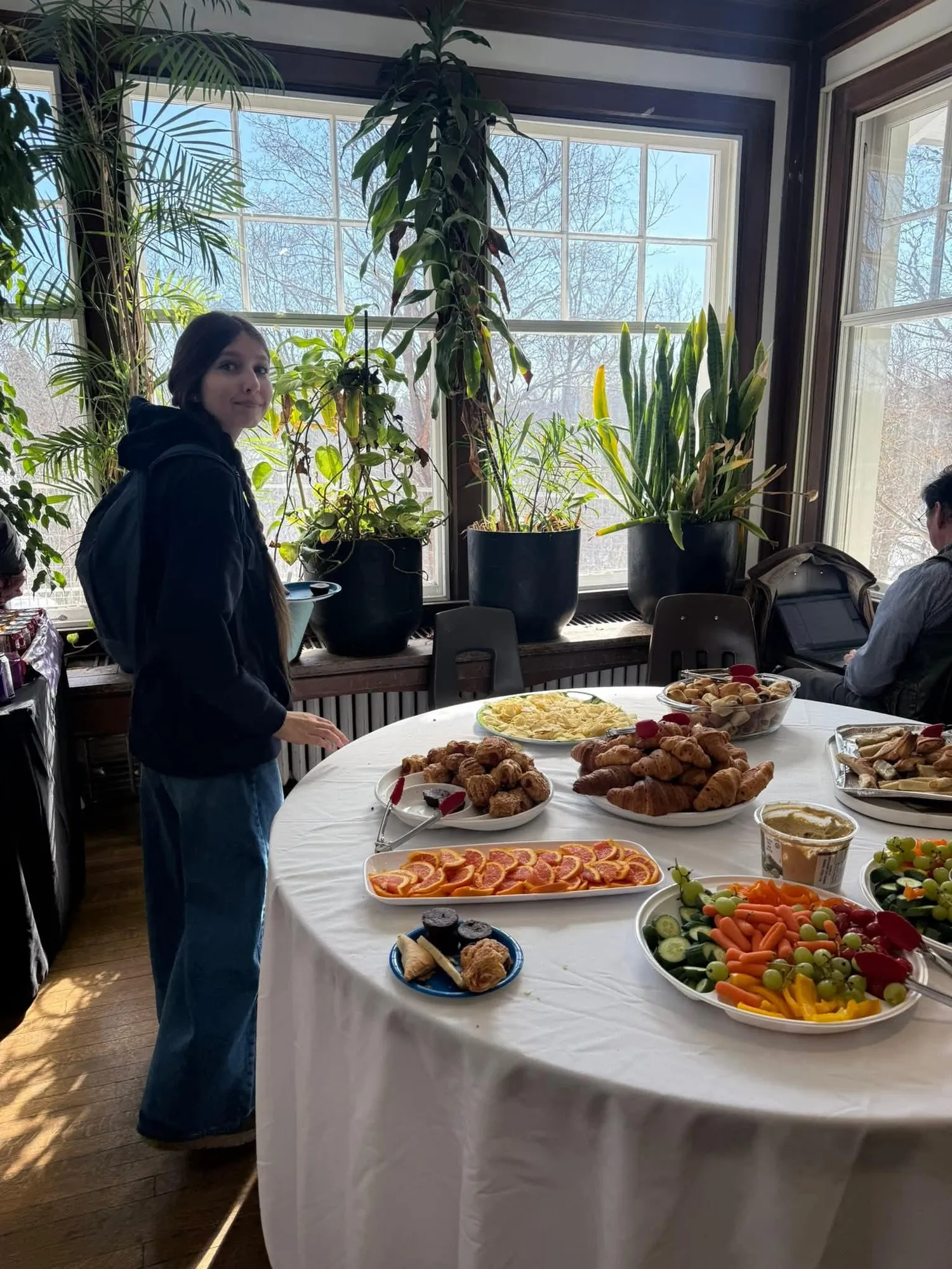Round table set with croissants, pastries, fruit, and vegetables at the opening reception